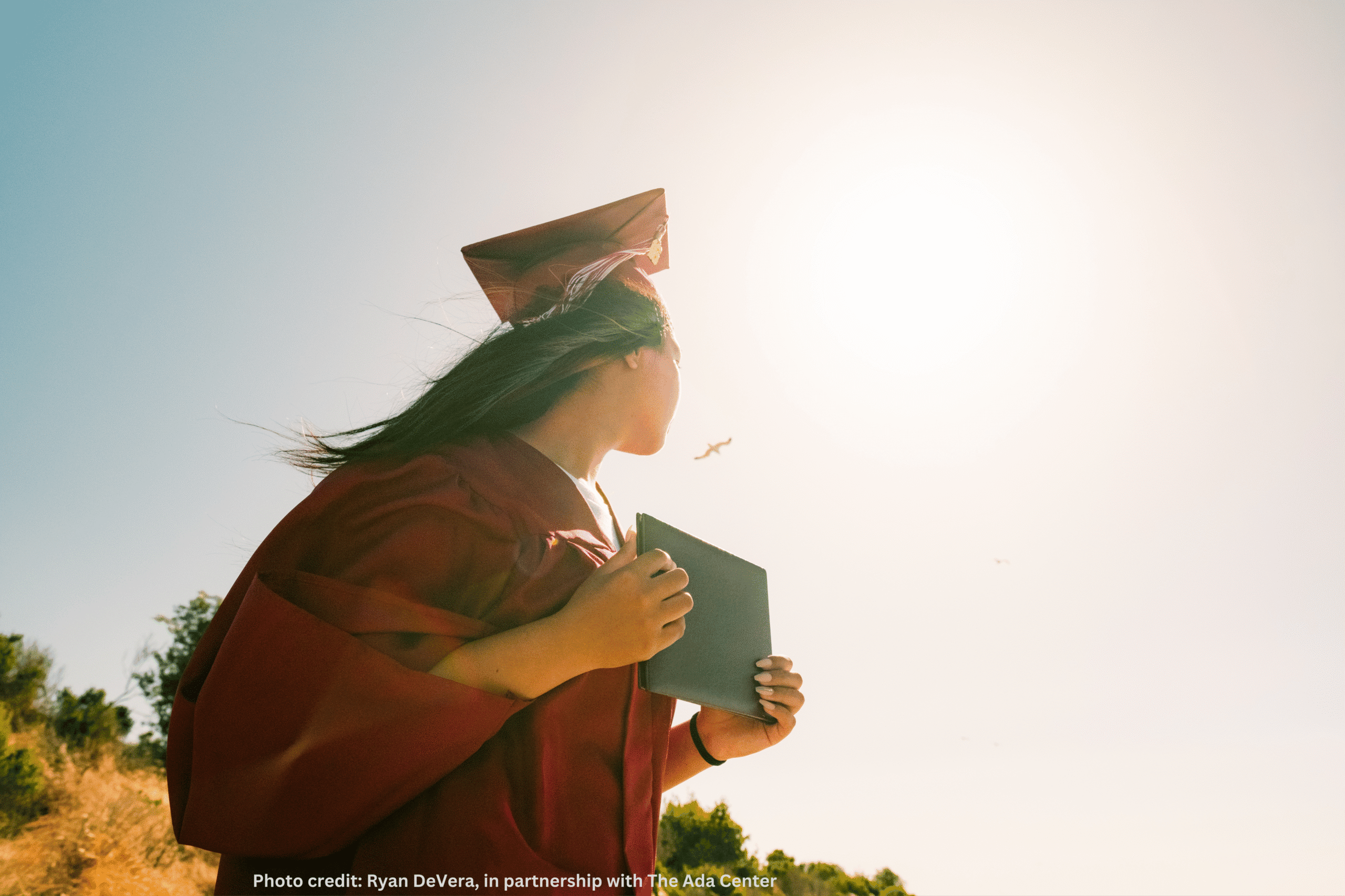 Graduate in cap and gown holding diploma, college student celebrating academic achievement at sunset, educational success, college graduation ceremony, higher education accomplishments.