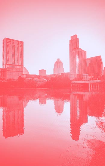 Downtown skyline of Columbus, Ohio with high-rise buildings reflected in the river, illustrating urban development and city growth.