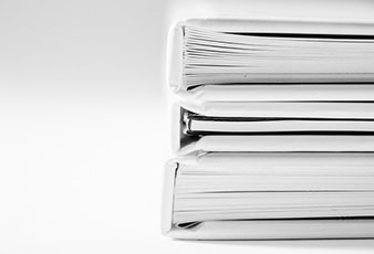 An organized stack of white paper documents on a white background, representing education or academic resources.