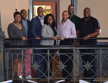 Diverse group of professionals standing on a balcony at a Complete College America event, promoting higher education success and college completion initiatives.