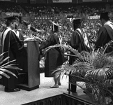 Graduates receiving diplomas at a college graduation ceremony.