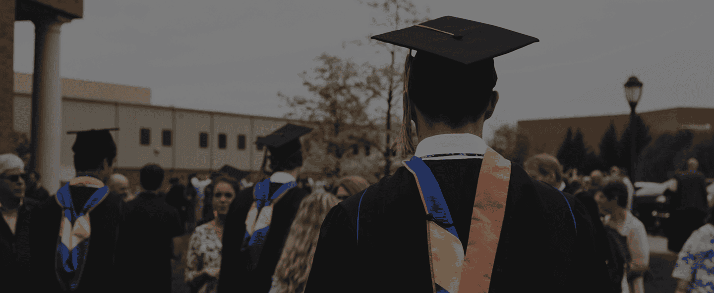 Graduates in caps and gowns at a college graduation ceremony, celebrating academic achievement and success in higher education.