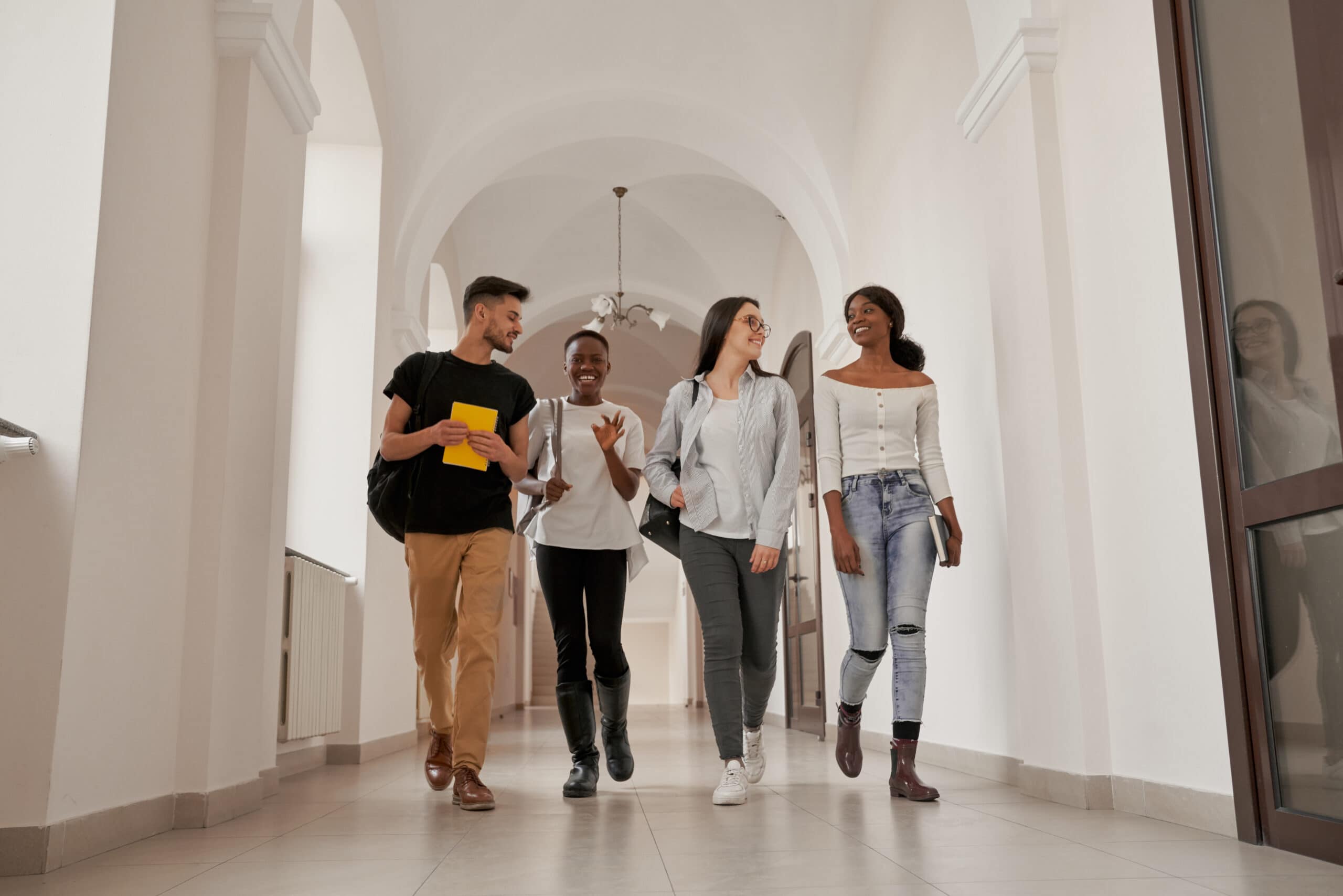 Diverse students walking confidently through a university hallway, representing higher education success and community at Complete College America.