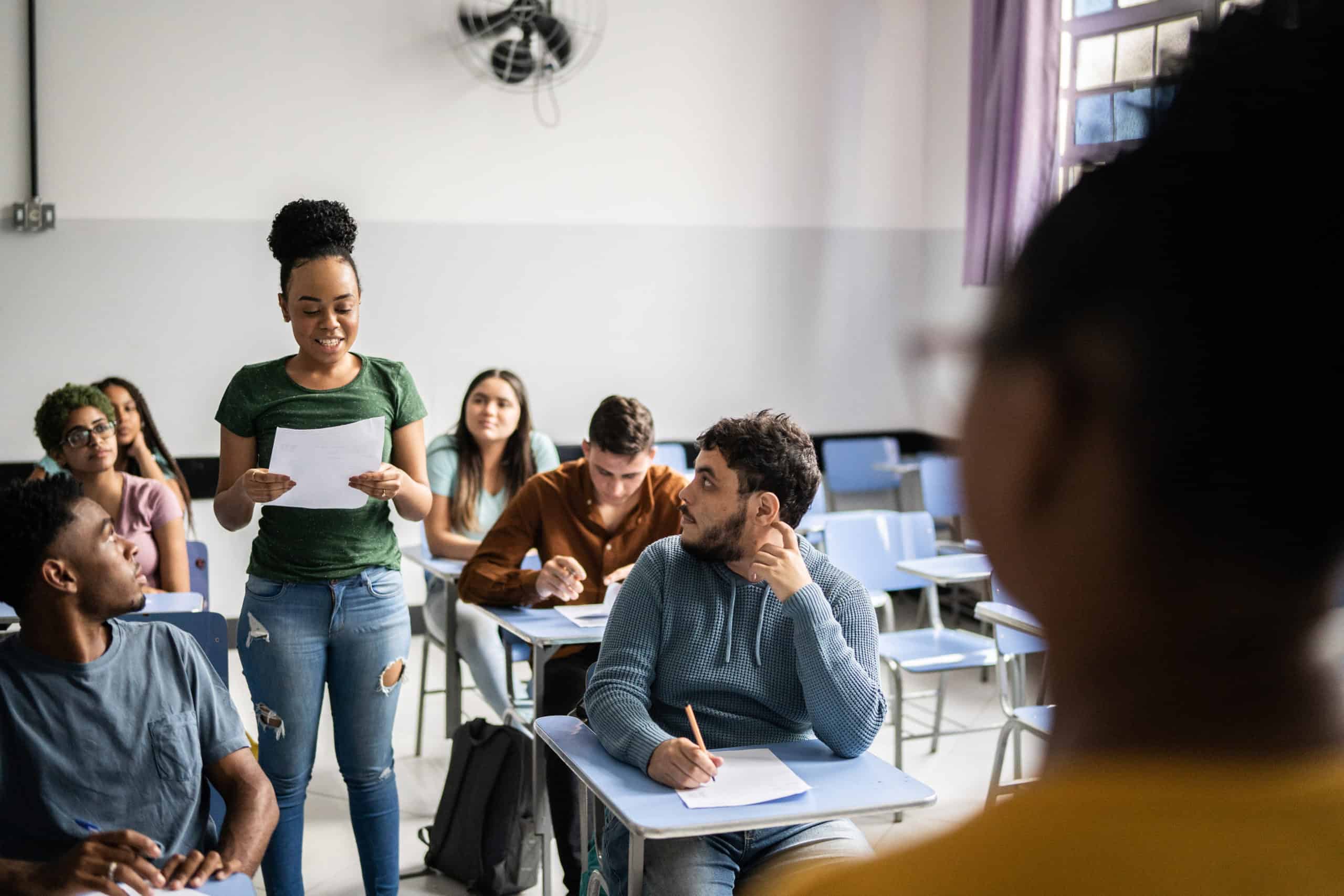 Student group in classroom participating in discussion, diverse college students engaging in active learning environment, college classroom with students and teacher, learning and education concept.