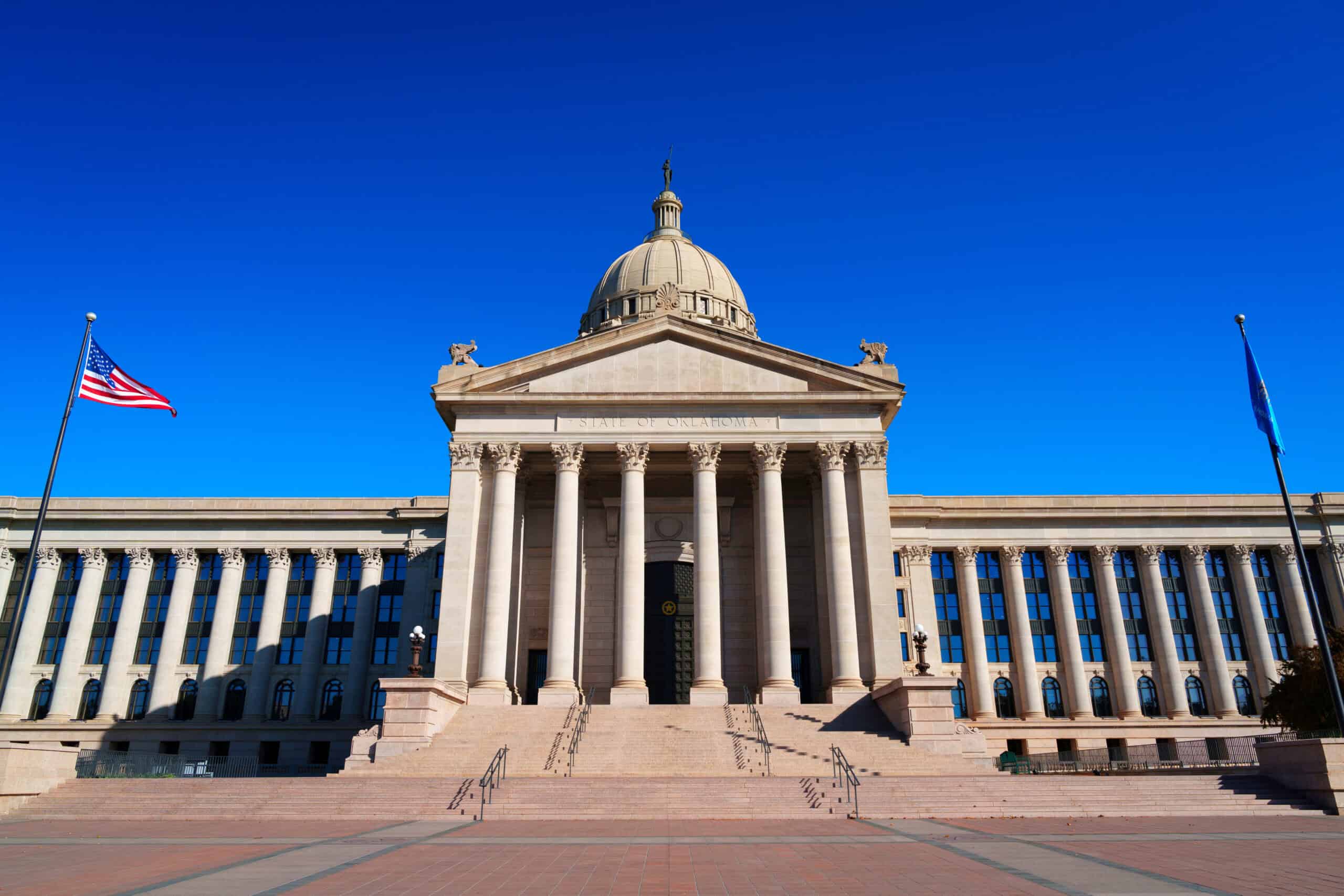 American government building with classical architecture, large columns, and dome under a clear blue sky, representing higher education and state government in Oklahoma.