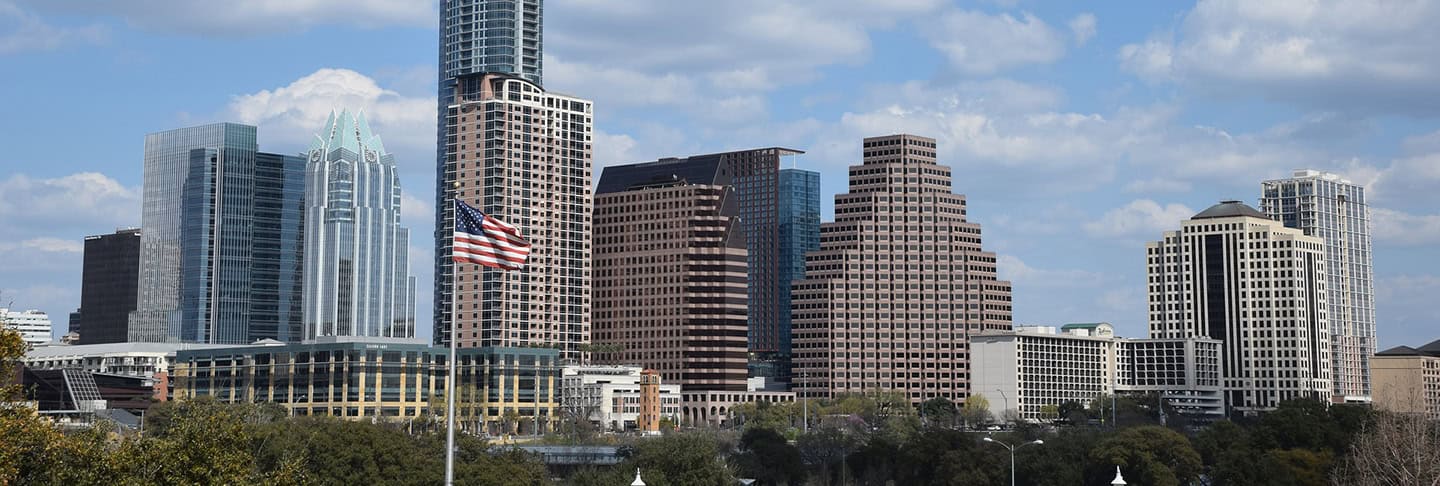 Austin, Texas skyline featuring modern skyscrapers, iconic city architecture, and a clear blue sky, representing vibrant urban growth and educational opportunities.