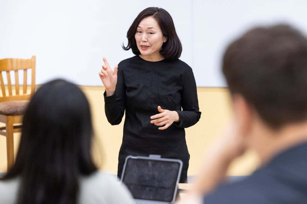 Innovative woman instructor engaging students in a college classroom, promoting higher education success and completion strategies for college students.