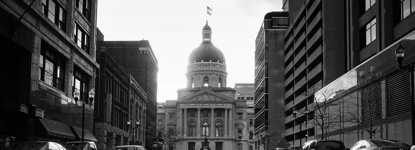 City skyline with historic government building and modern office buildings in black and white, symbolizing educational achievement and civic engagement for Complete College America.