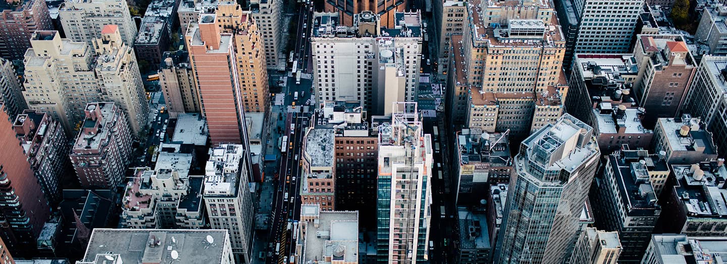 Skyline view of a dense urban city with tall skyscrapers and commercial buildings in the daytime, representing education, innovation, and progress in higher education and college completion initiatives.