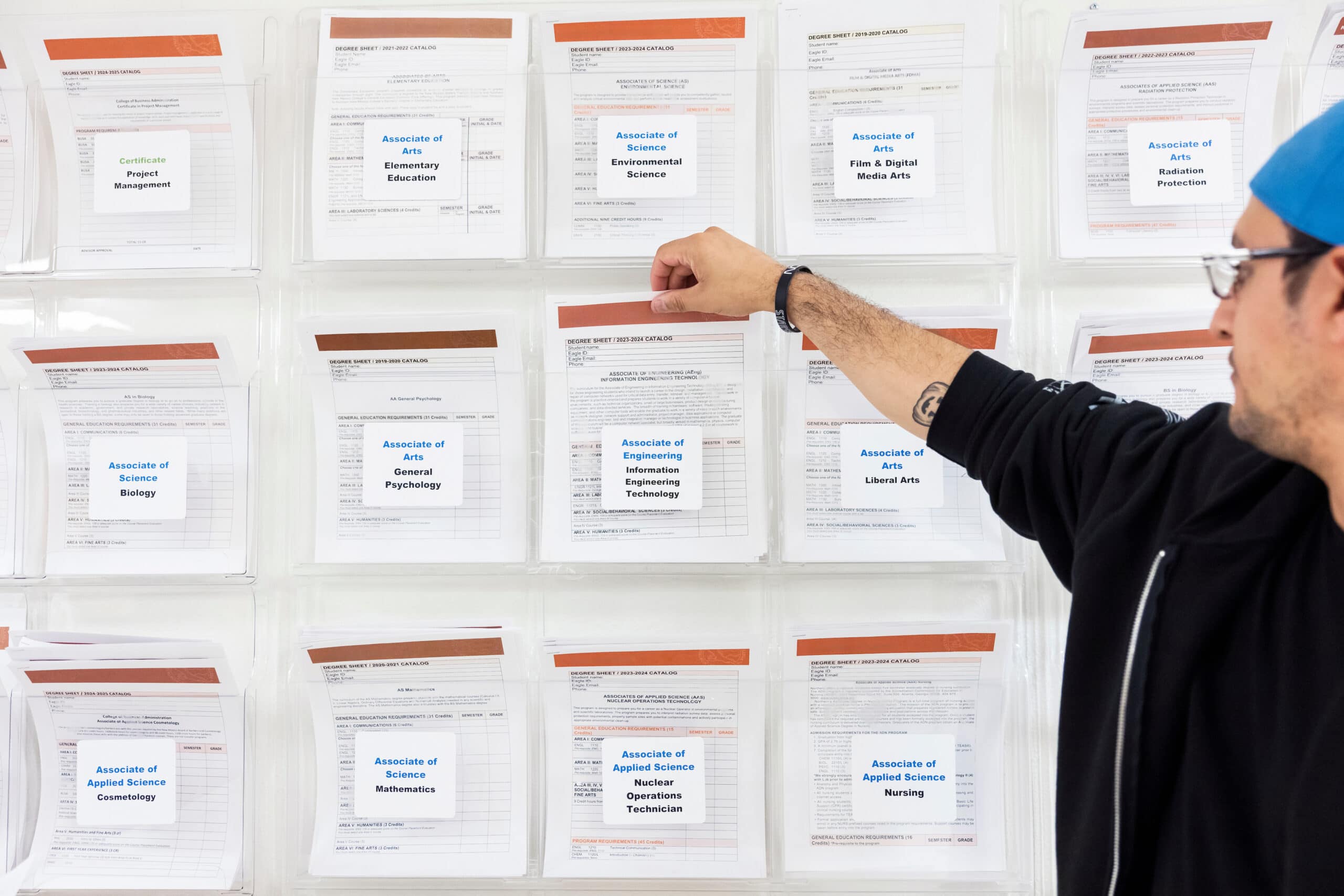 Associate of Arts, Environmental Science degree sheet displayed behind a person selecting a degree from the catalog.