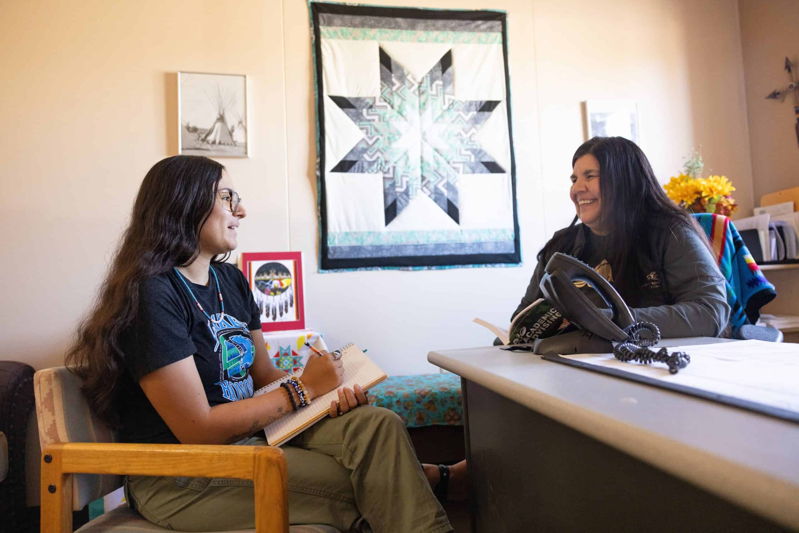 - Diverse college students engaged in conversation at an academic advising session.