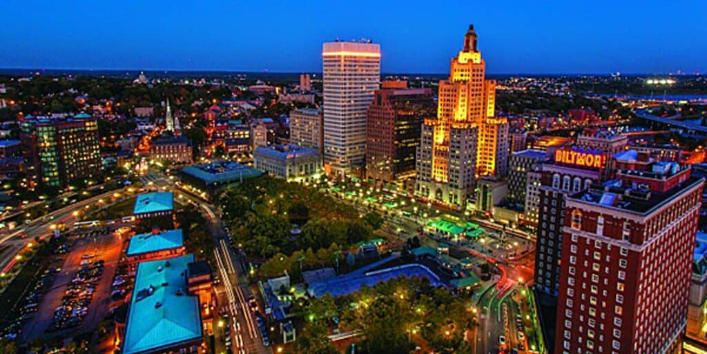 Aerial view of Baltimore skyline at night with illuminated buildings, skyline lights, and city streets, showcasing urban development and vibrant city life.