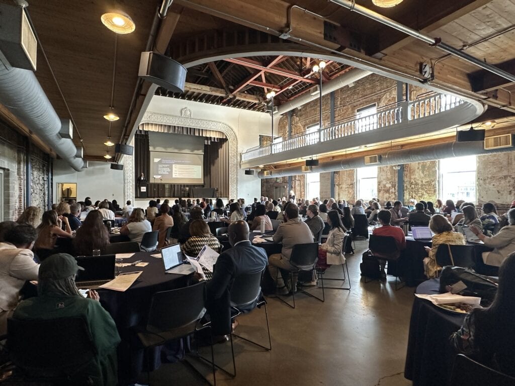 Conference room with diverse attendees at a college summit or educational event, emphasizing collaboration and higher education initiatives.