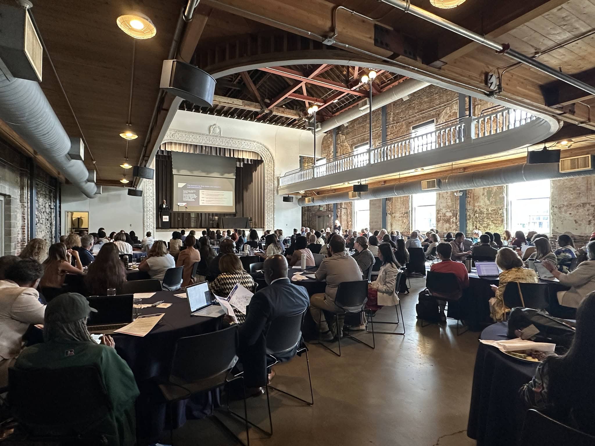 Conference room with diverse attendees at a college summit or educational event, emphasizing collaboration and higher education initiatives.