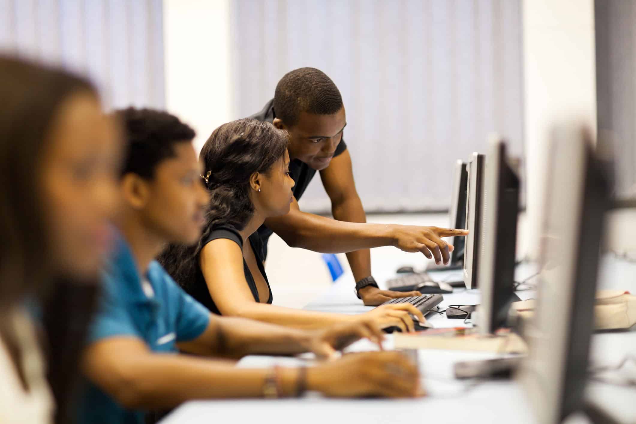 Students learning in a computer lab for higher education, educational technology, college students working on computers, university training environment, digital literacy in college campuses.