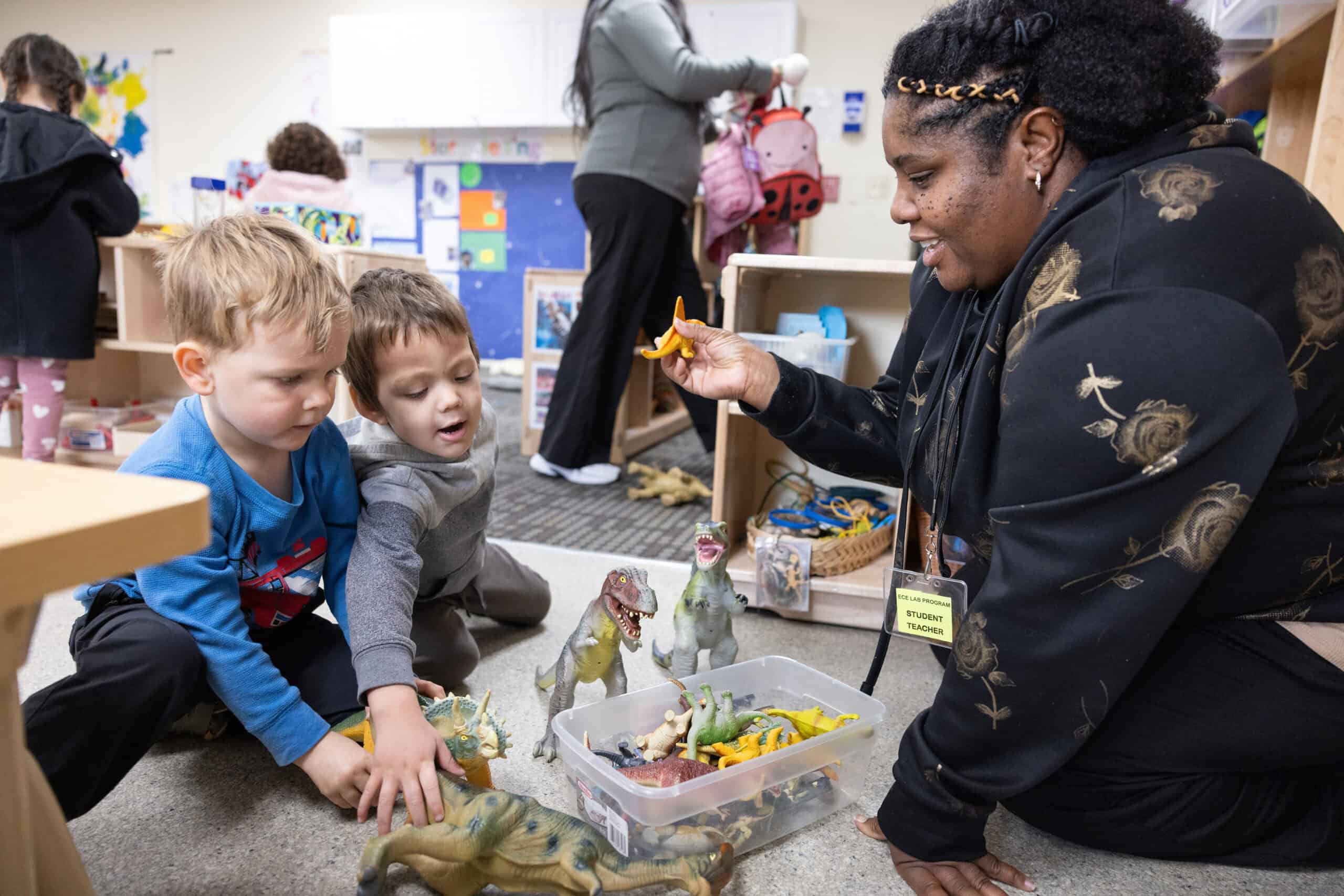 Student teacher playing with children at a childcare center on a college campus.