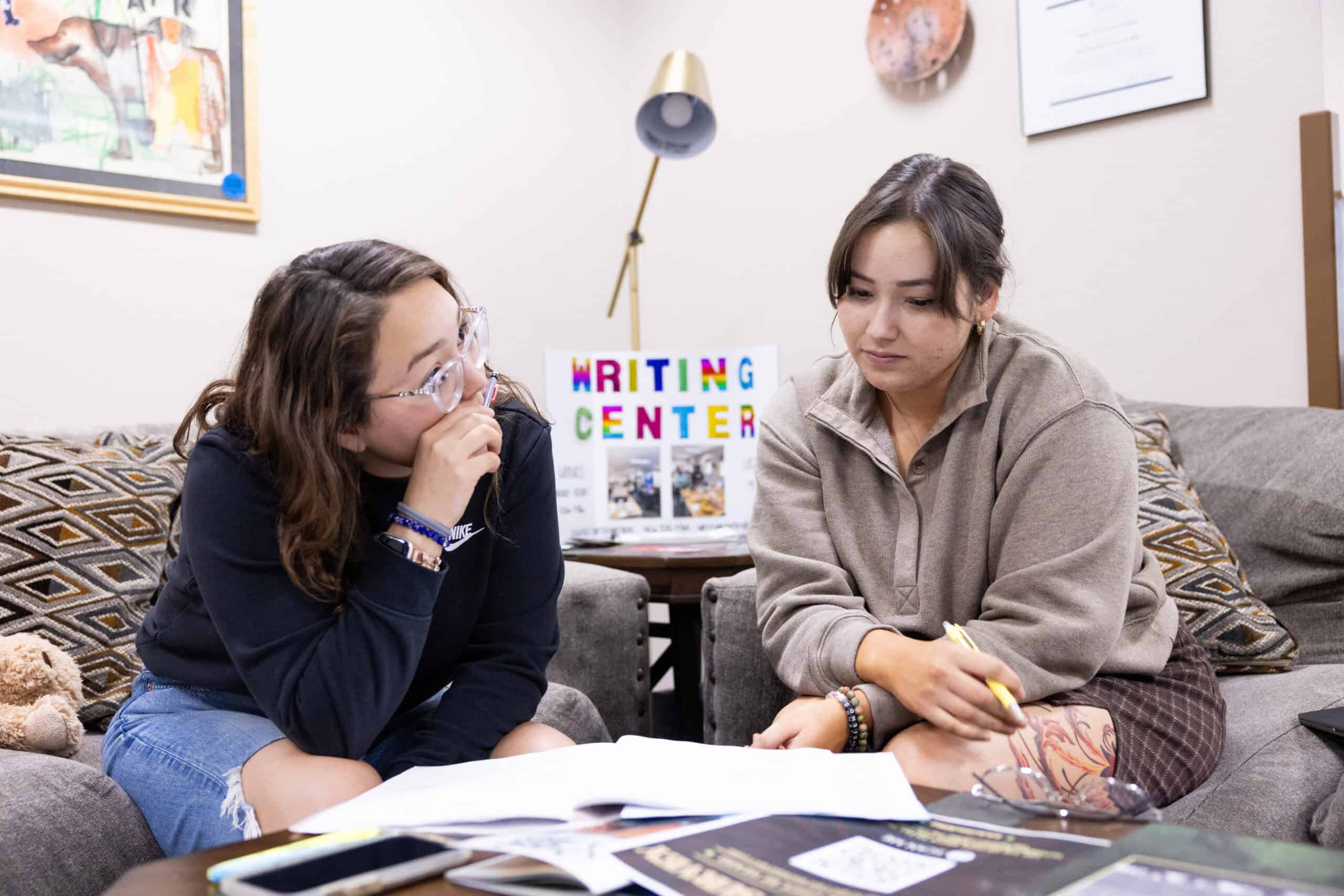Struggling students receiving tutoring at a college writing center for improved academic success.