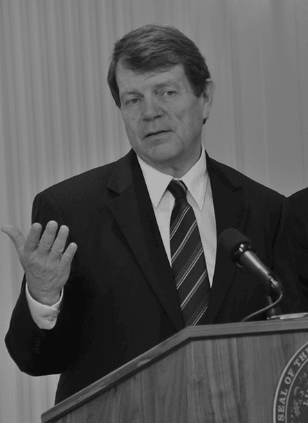 State representative speaking at a podium during an event promoting higher education initiatives.